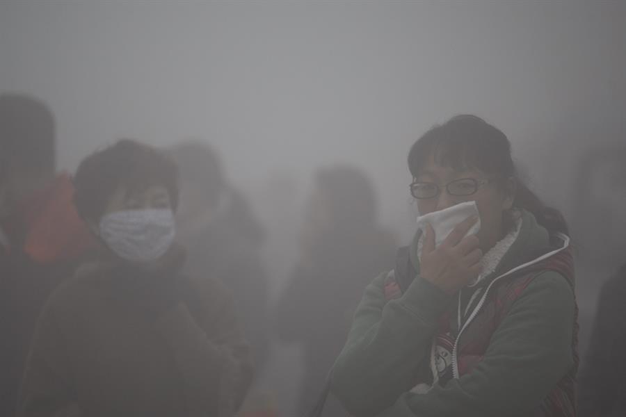 Un grupo de personas se cubre la cara mientras atraviesa una densa nube de esmog en Harbin, en la provincia de Heilongjiang (China). Medioambiente