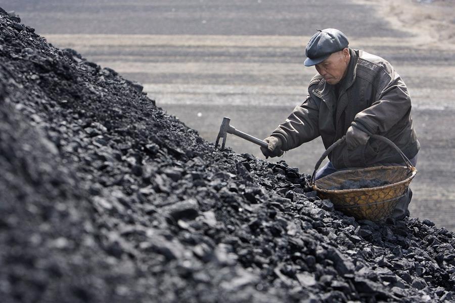 Un hombre recolecta carbón desechado por las minas en Jixi (China). La gente recoge este material para usarlo como fuente de calor y cocinar en sus hogares.