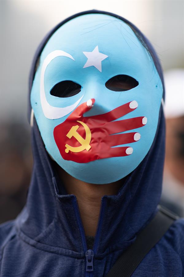 Un manifestante usa una máscara durante una manifestación en apoyo de los musulmanes uigures de Xinjiang. (Efe)